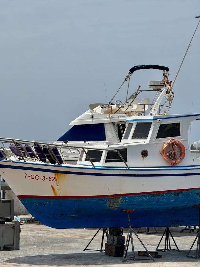 Colorful fishing boat docked at a harbor in Lanzarote, Spain under a clear sky.